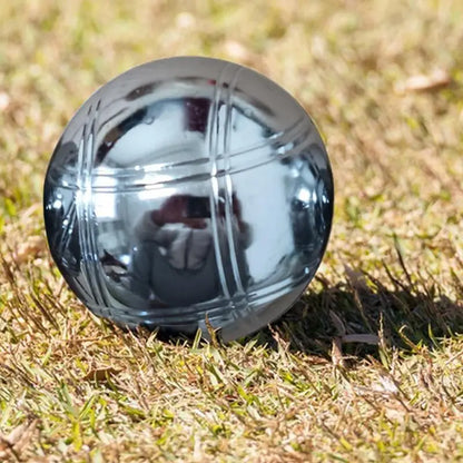 Boule de pétanque en métal gravé sur herbe verte, élégante et unique.